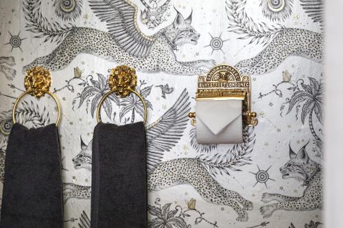 a pair of gold earrings hanging on a wall at Georgina in Lavenham