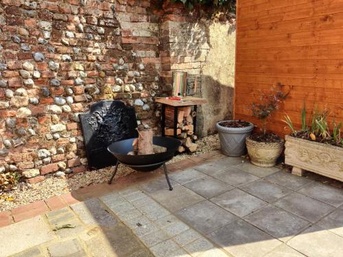 a outdoor patio with a grill and a cat sitting in a bowl at Georgina in Lavenham