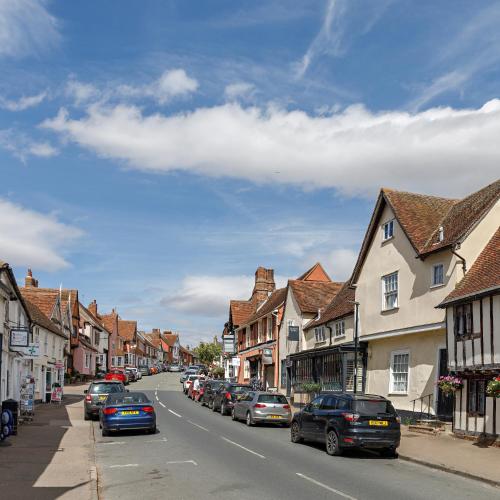 a town street with cars parked on the side of the road at Georgina in Lavenham