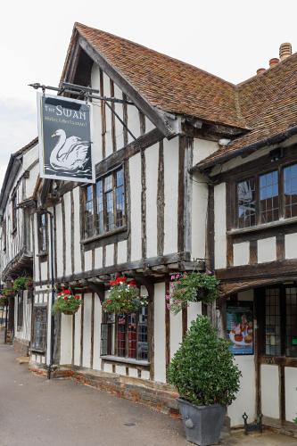 a building with a swan sign on the side of it at Georgina in Lavenham