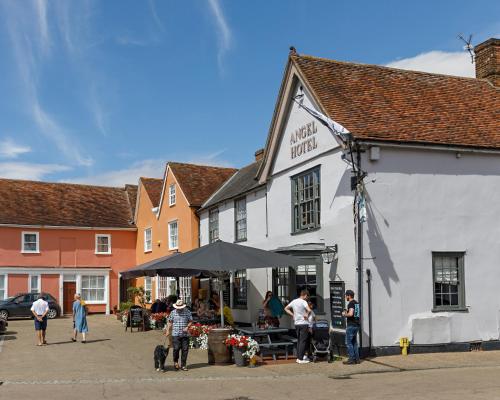 a group of people standing outside of a white building at Georgina in Lavenham