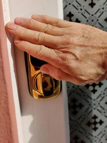 a hand is unlocking a door with a door knob at Georgina in Lavenham