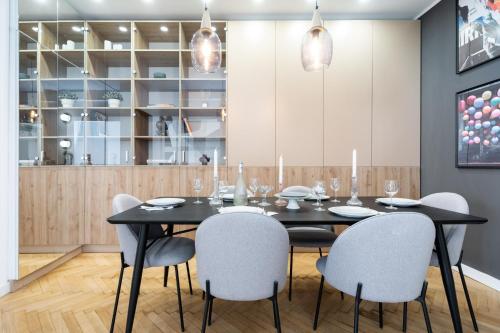 comedor con mesa negra y sillas en Qult - The Architect, en Bucarest