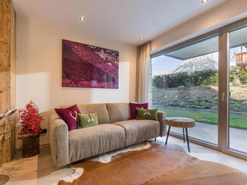 a living room with a couch and a large window at Zum Wilden Mats in Going