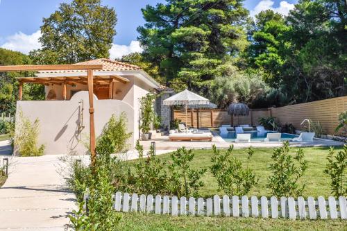 a backyard with a white picket fence at Mandraki Village Boutique Hotel in Koukounaries