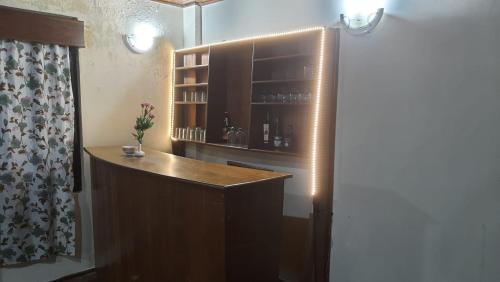 um quarto com um bar com uma estante de livros em Hotel Pemathang em Pemayangtse