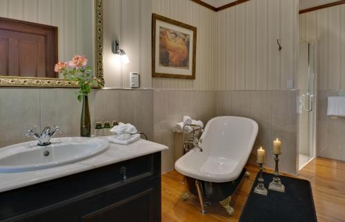 a bathroom with a toilet and a sink and a mirror at The Peppertree Luxury Accommodation in Blenheim