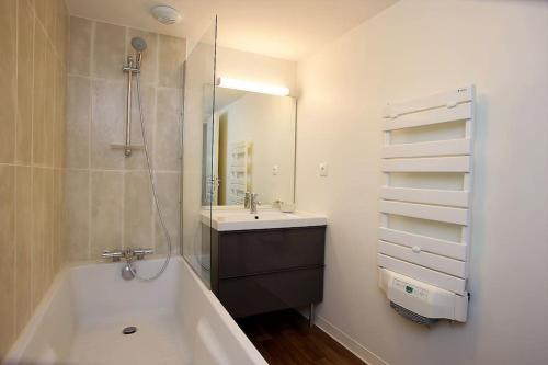 La salle de bains est pourvue d'une baignoire, d'un lavabo et d'un miroir. dans l'établissement Les beaux châteaux, à Vouvray