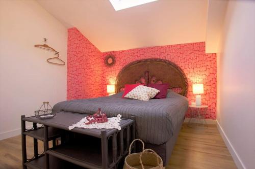 - une chambre avec un lit et un mur en briques rouges dans l'établissement Les beaux châteaux, à Vouvray