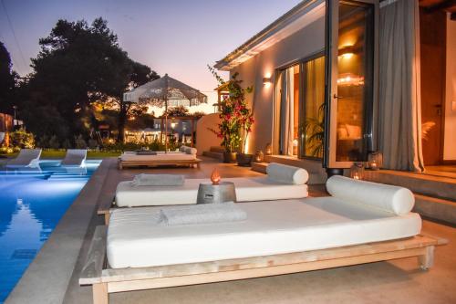 a large bed on a patio next to a pool at Mandraki Village Boutique Hotel in Koukounaries