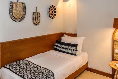 a small bedroom with a bed and pillows on it at Mandraki Village Boutique Hotel in Koukounaries
