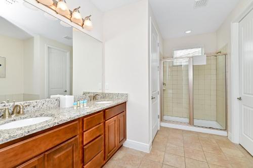 y baño con 2 lavabos y ducha. en Modern Home by Rentyl with Private Pool and Jacuzzi near Disney - 7389M, en Orlando