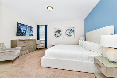 1 dormitorio blanco con 1 cama y 1 silla en Modern Home by Rentyl with Private Pool and Jacuzzi near Disney - 7389M, en Orlando