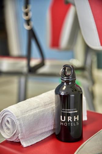a bottle ofnir hotter sitting next to a towel at URH Sitges Playa in Sitges