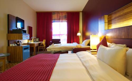 a hotel room with two beds and a television at Radisson Blu Hotel Belfast in Belfast
