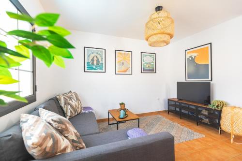 a living room with a couch and a tv at Casa Armonia - Private Pool near the Beach in Corralejo