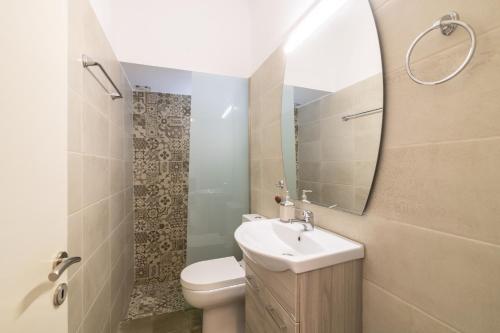 y baño con lavabo, aseo y espejo. en Bilocale - Δίχωρο διαμέρισμα δίπλα στα Ψηλαλώνια en Patras