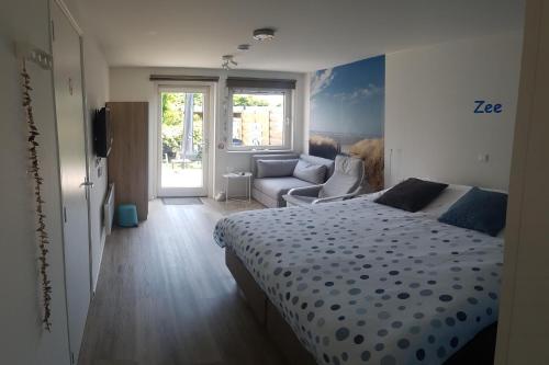 een slaapkamer met een bed en een bank bij Duin en Zee Texel in De Koog