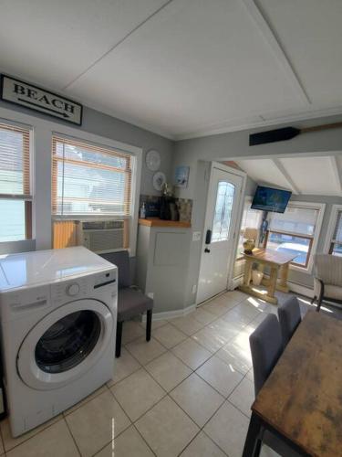 a kitchen with a washing machine and a table at Beachy Bay Breeze Bungalow 2BR with parking and close to many amenities. in West Haven