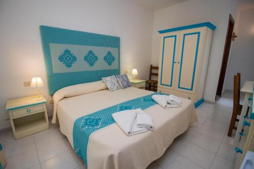 a bedroom with two beds with towels on them at Hotel Canne al Vento in Santa Teresa Gallura