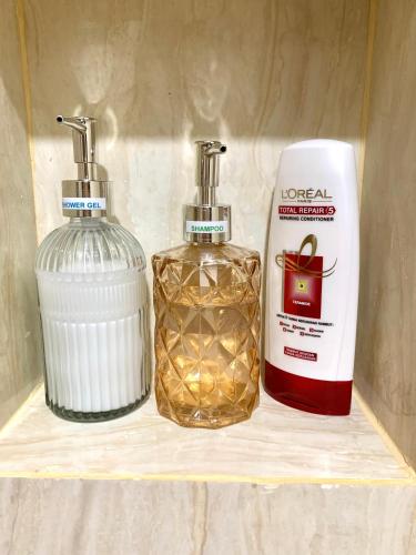 two bottles of soap sitting on a shelf next to a soap dispenser at Wiwi Formosa Residence -Triple bed-Balcony-Netflix in Nagoya