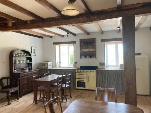 una cocina con mesas y sillas de madera en una habitación en Rustic cottage with stunning swimming pool en Saint-Front