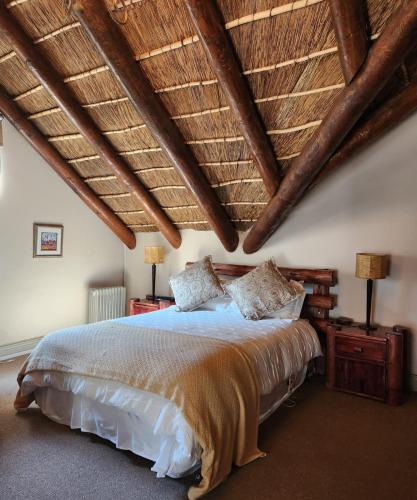 a bedroom with a large bed with a wooden ceiling at Traduire in Cape Town
