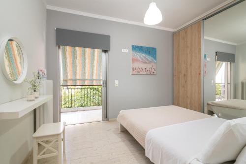 Habitación blanca con cama y baño. en Bilocale - Δίχωρο διαμέρισμα δίπλα στα Ψηλαλώνια en Patras