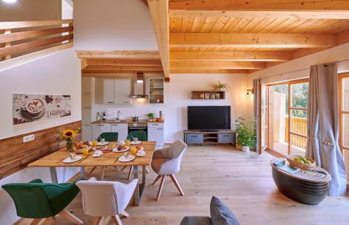 a kitchen and living room with a wooden table and chairs at Ferienwohnung Tittmoning zwischen Salzburg und Burghausen in Tittmoning