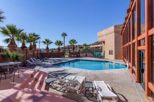 a swimming pool with lounge chairs and a table at Red Lion Hotel and Conference Center St. George in St. George