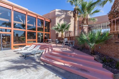 a building with benches and tables and palm trees at Red Lion Hotel and Conference Center St. George in St. George