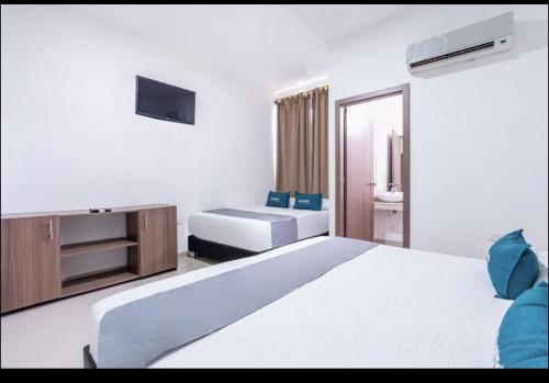 a hotel room with two beds and a television at Hotel Millrose in Valledupar