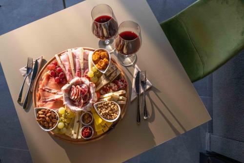 a table with a plate of food and two glasses of wine at Divina Charme in Mascalucia