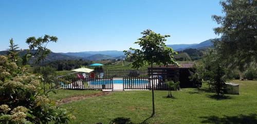 una casa con piscina y montañas en el fondo en gîtes "Entre les Vignes", en Tourreilles