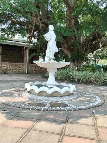 a statue of a woman sitting on a fountain at The Farmers Lodge in Thorndale