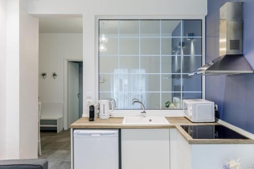 a kitchen with a sink and a window at NAVA Apartment in the center with private parking of stayinthess in Thessaloniki