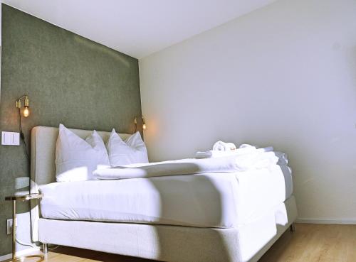una camera da letto con un grande letto con lenzuola bianche di coSI Apartment im SI-Centrum Stuttgart a Stoccarda