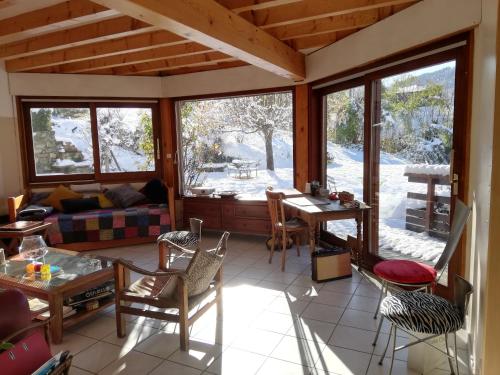 a living room with a couch and a table and chairs at Eco-Logis Mad'in Belledonne in Theys