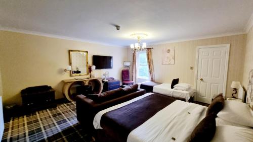 a hotel room with a large bed and a couch at Muthu Belstead Brook Hotel in Ipswich
