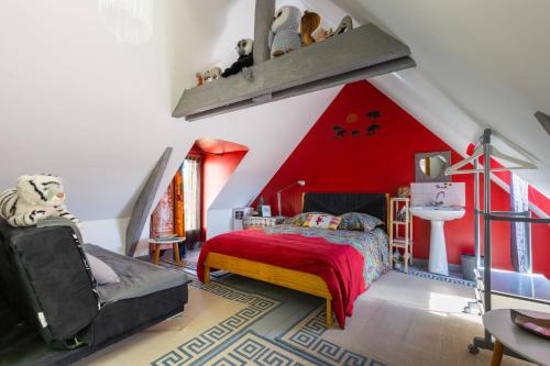 a bedroom with a red ceiling with a bed and a chair at Le petit secret in Saint-Aignan