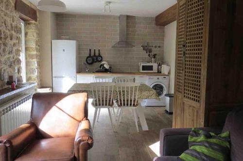 a living room with a table and a kitchen at Apartamento en Cantabria, Treceño in Treceño