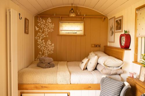Pen y Clawdd的住宿－Harrys Hideout - Shepherd's Huts at Harrys Cottages，一间小房间的卧室,配有一张床铺