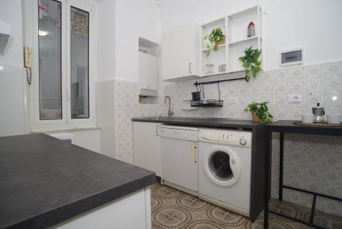 una cocina blanca con lavadora. en CASA Candida en Génova