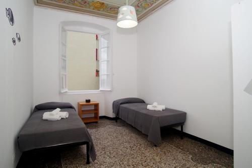 Habitación con 2 camas y espejo. en CASA Candida en Génova