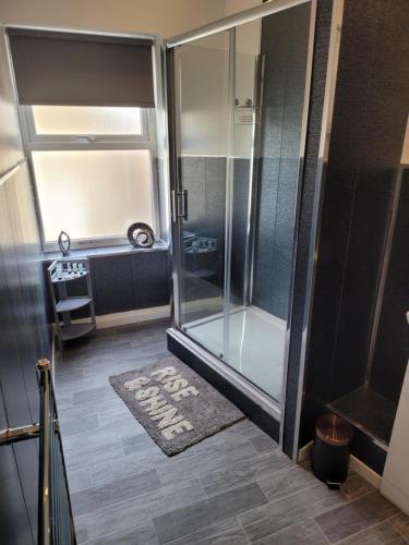 baño con ducha y alfombra en el suelo en Elegance apartments en West Cornforth