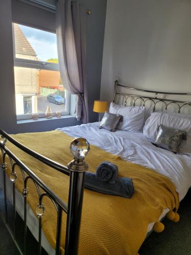 Un dormitorio con una cama grande con una ventana grande. en Elegance apartments, en West Cornforth