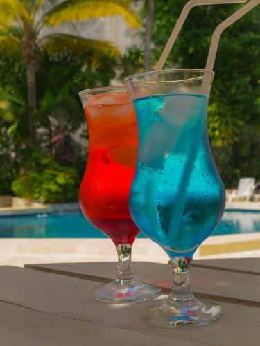 two cocktails sitting on a table next to a pool at Grand Hotel Mercedes in Pucallpa