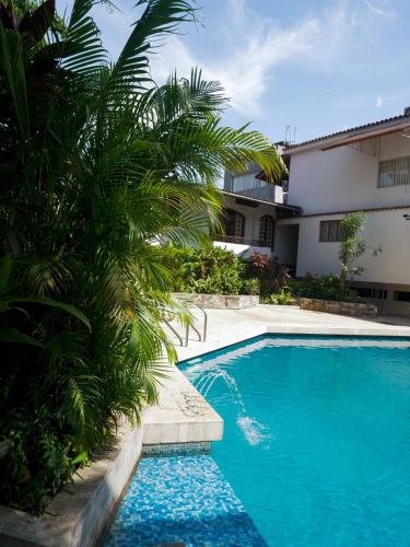 a swimming pool with a palm tree next to a building at Grand Hotel Mercedes in Pucallpa