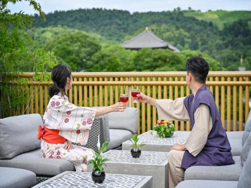 a woman and a man are playing a game of wii at Hotel New Wakasa in Nara