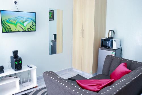 un soggiorno con un divano e una televisione di JSTAY a Nairobi